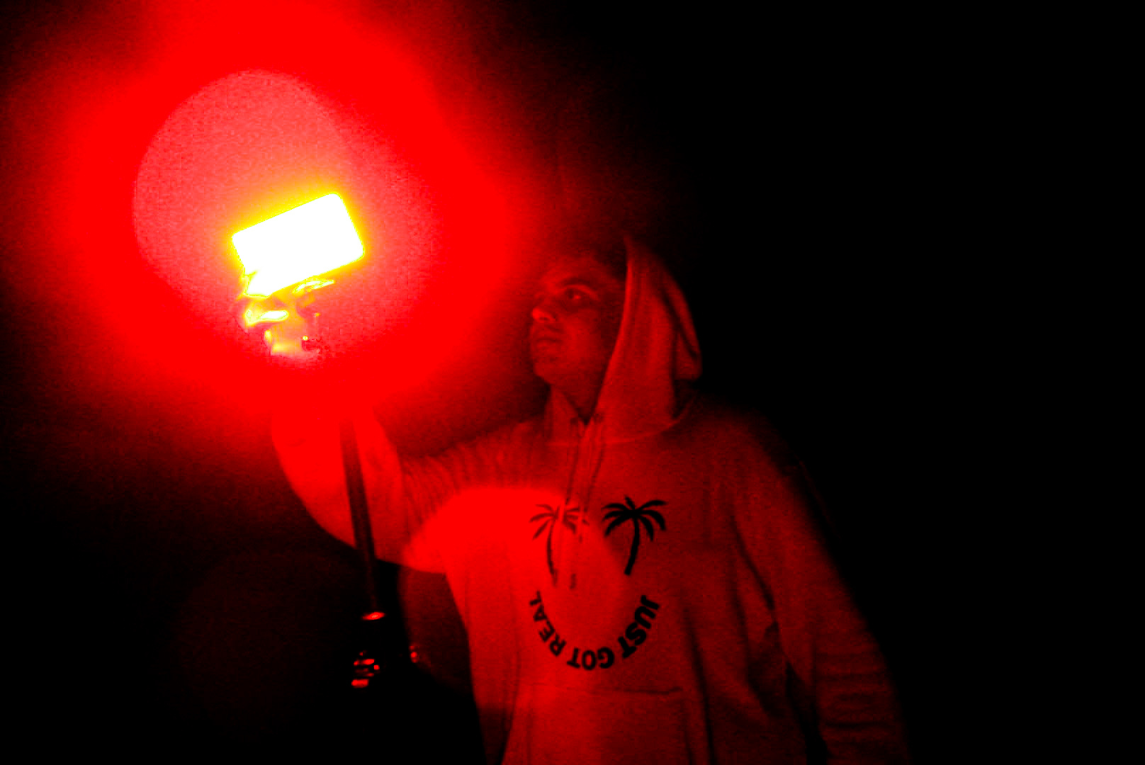 Daniel Ali holding a red light